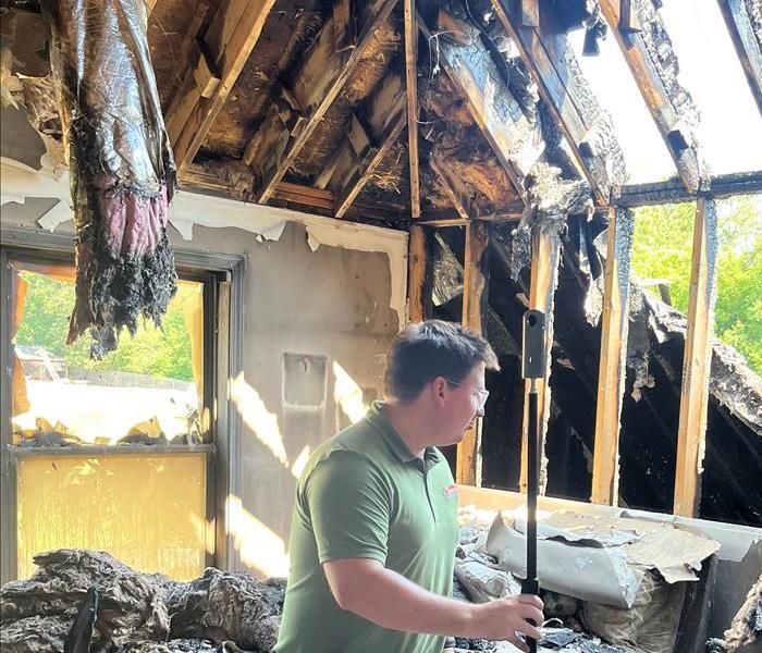man standing in a burnt house